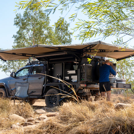 Ute with a 270 XT MAX Awning open over its canopy doors, among trees and long grass